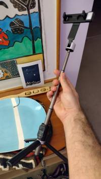 Item 2. A hard plastic gray and black telescoping stand with cradle on one end and tripod legs on the other.